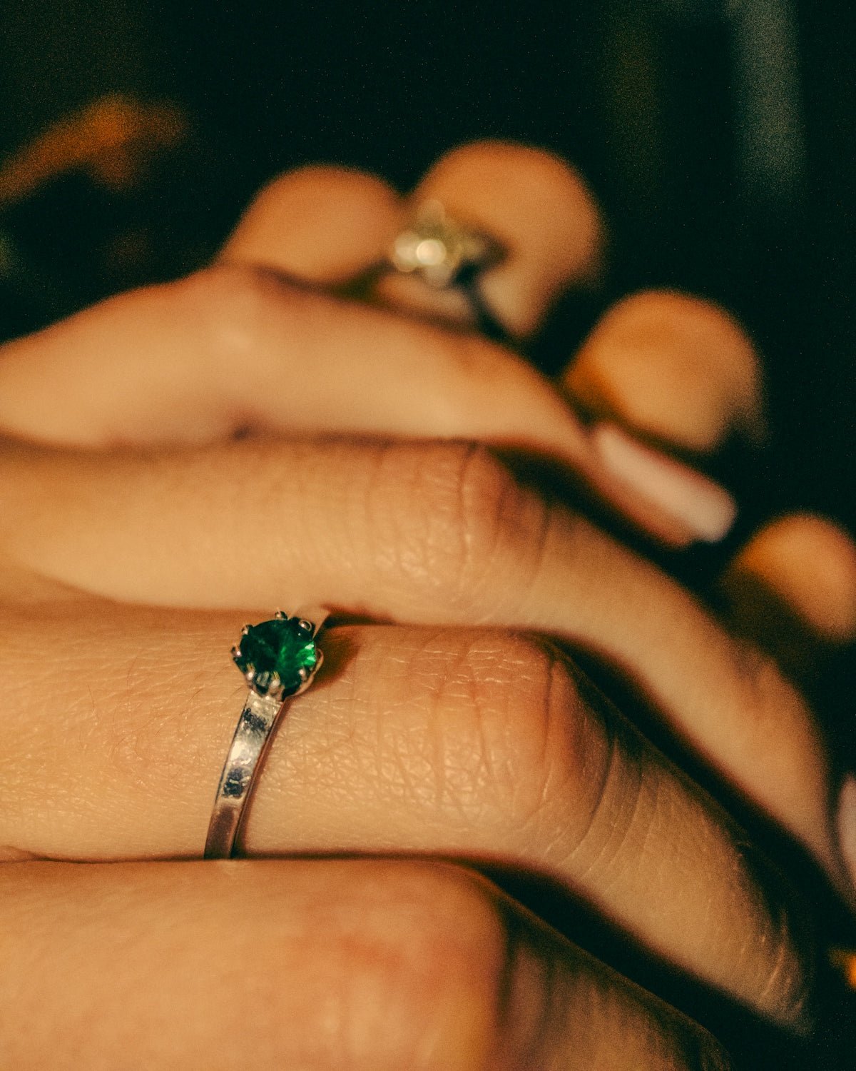 Close-up of a hand wearing an emerald ring