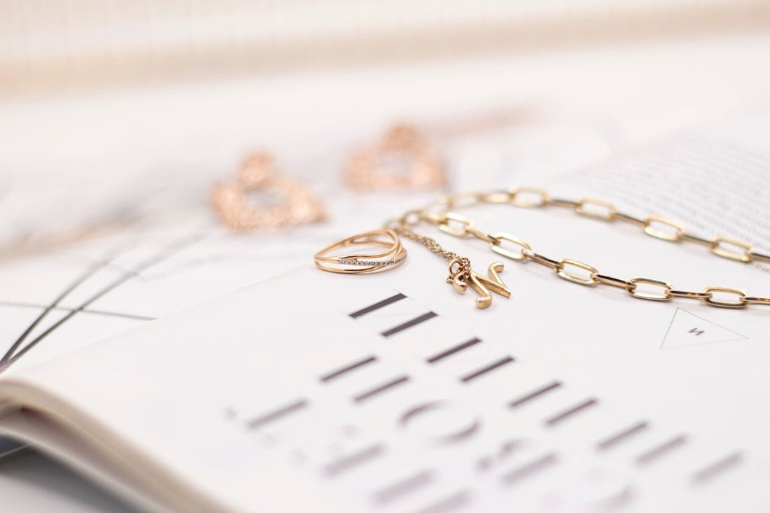 gold necklace on white paper