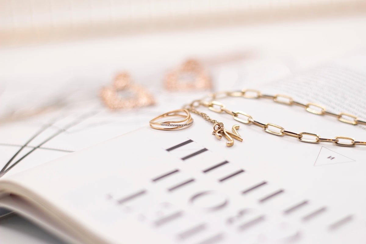 gold necklace on white paper