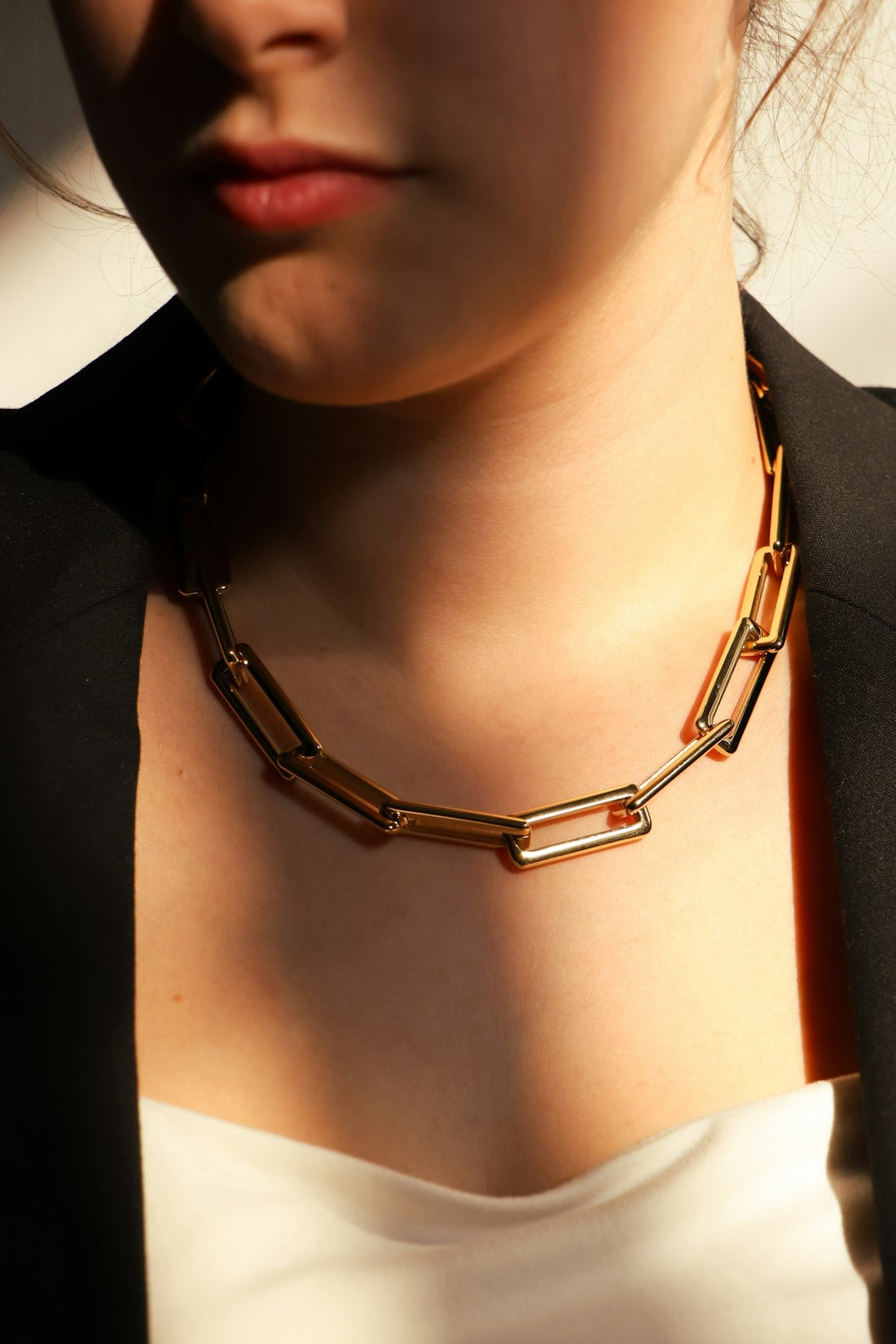 A woman wears a chunky gold chain necklace.