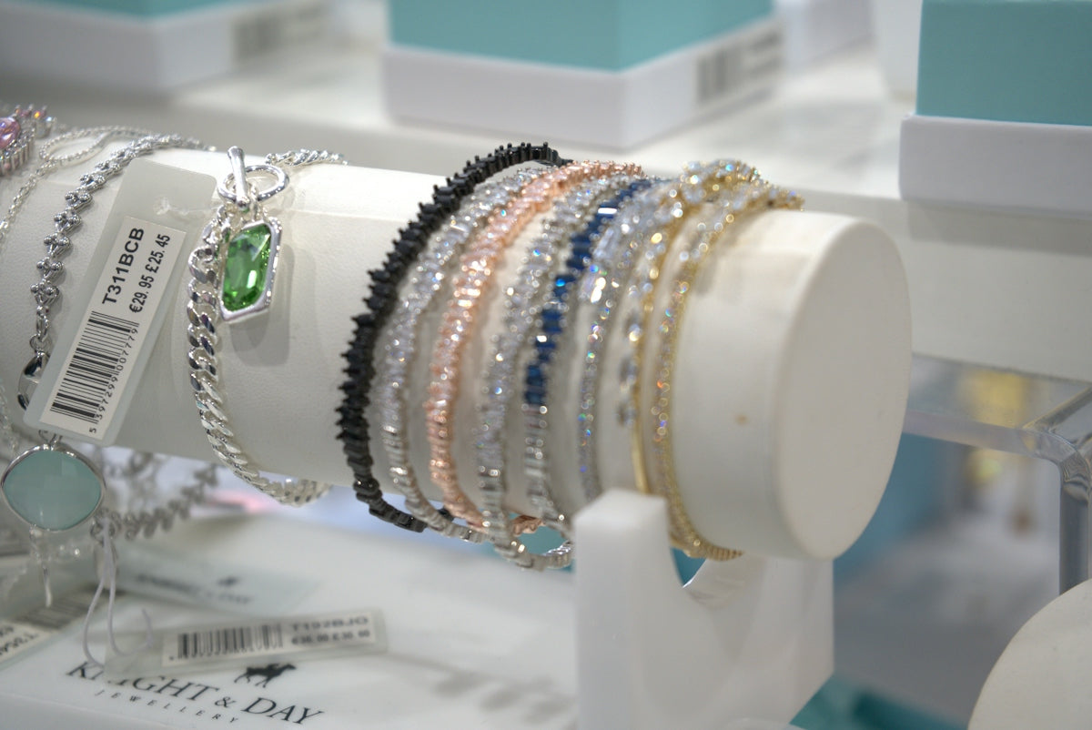 Bracelets are displayed on a white jewelry stand