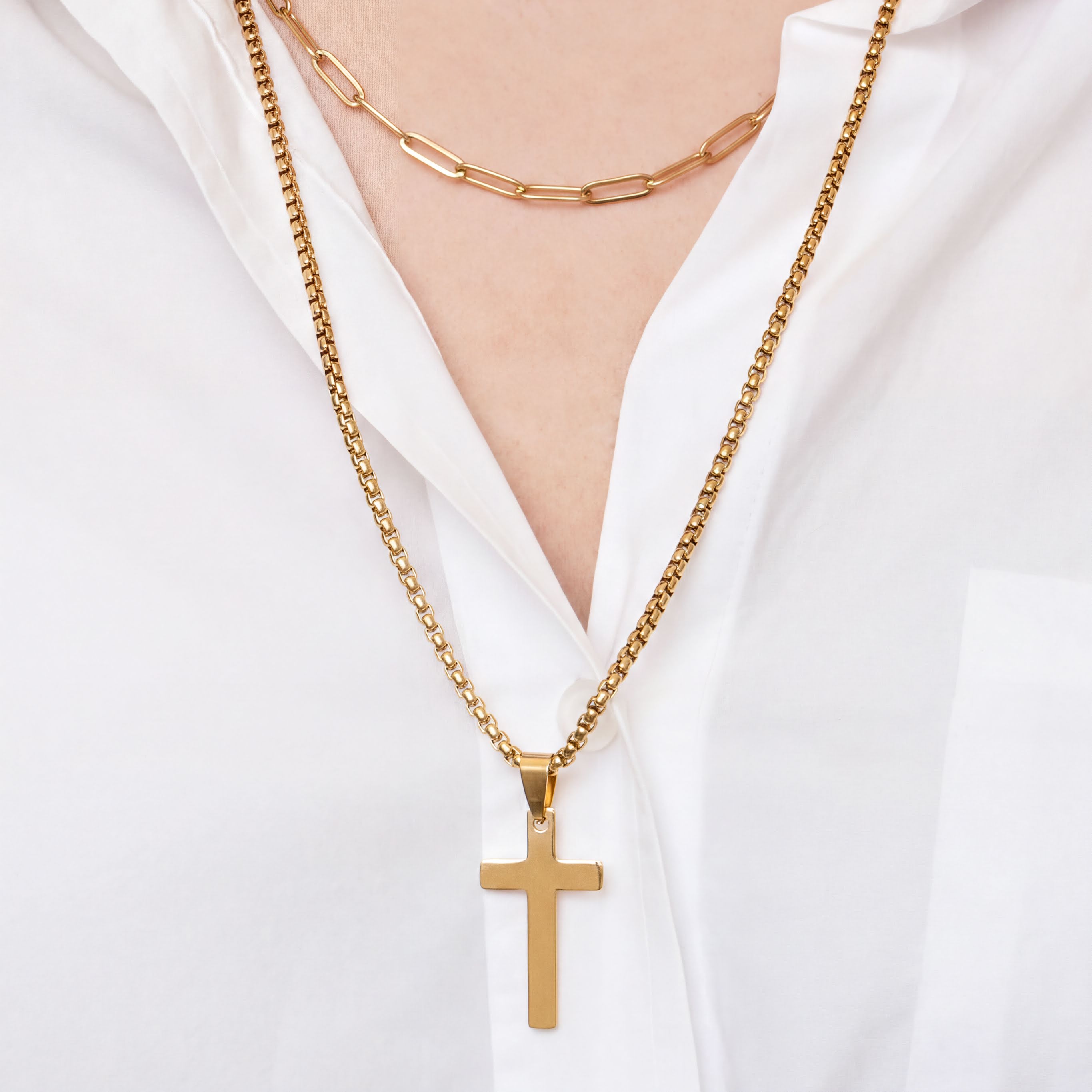 Gold necklace with a cross pendant on a white background