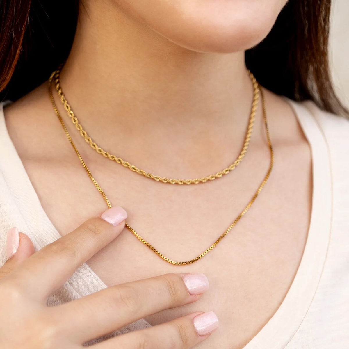 Gold chain necklace on a person with a blurred background