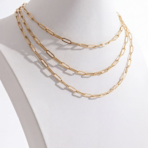 Gold chain necklace on a mannequin neck against a white background