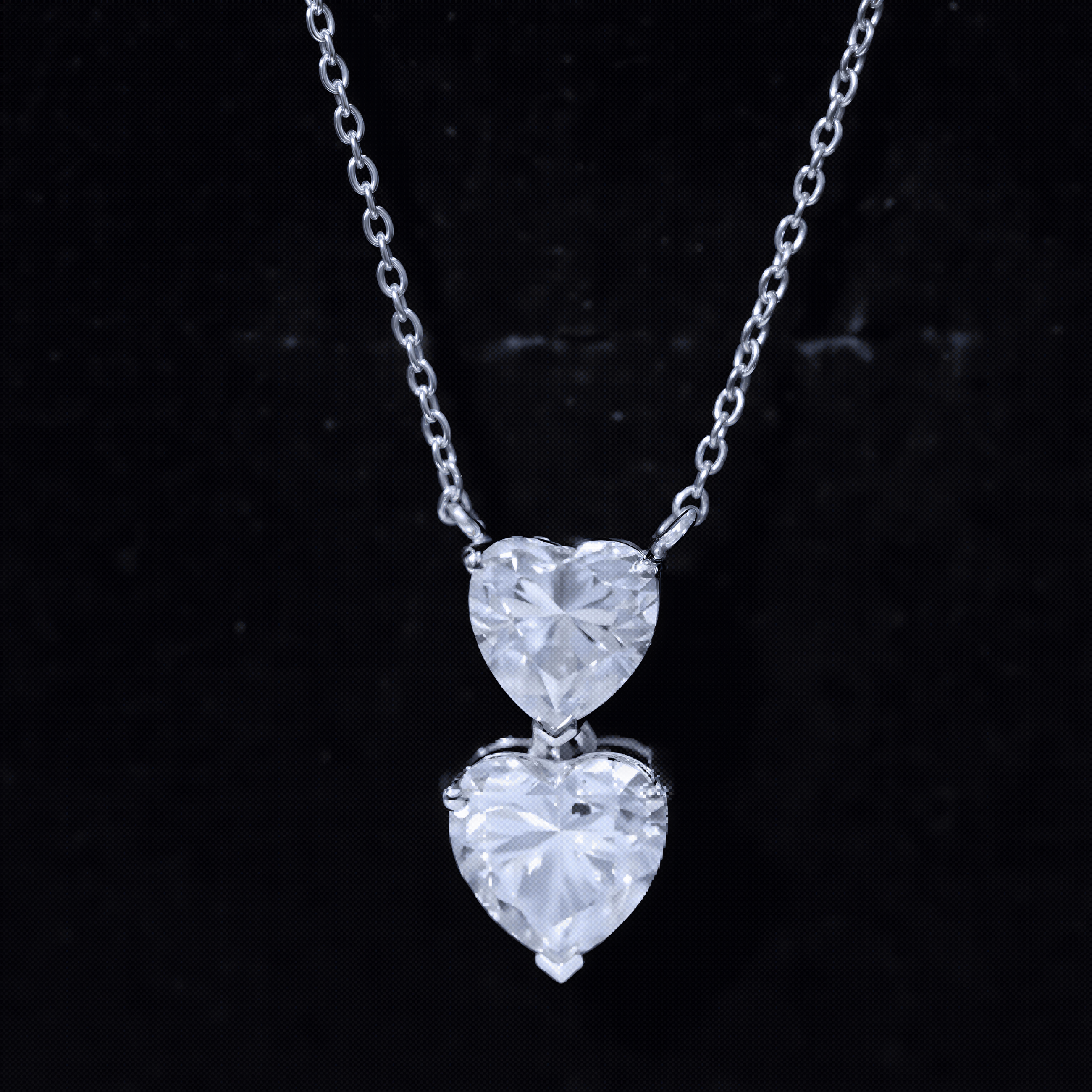 A necklace with two large, clear heart-shaped diamonds suspended from a chain against a dark background.