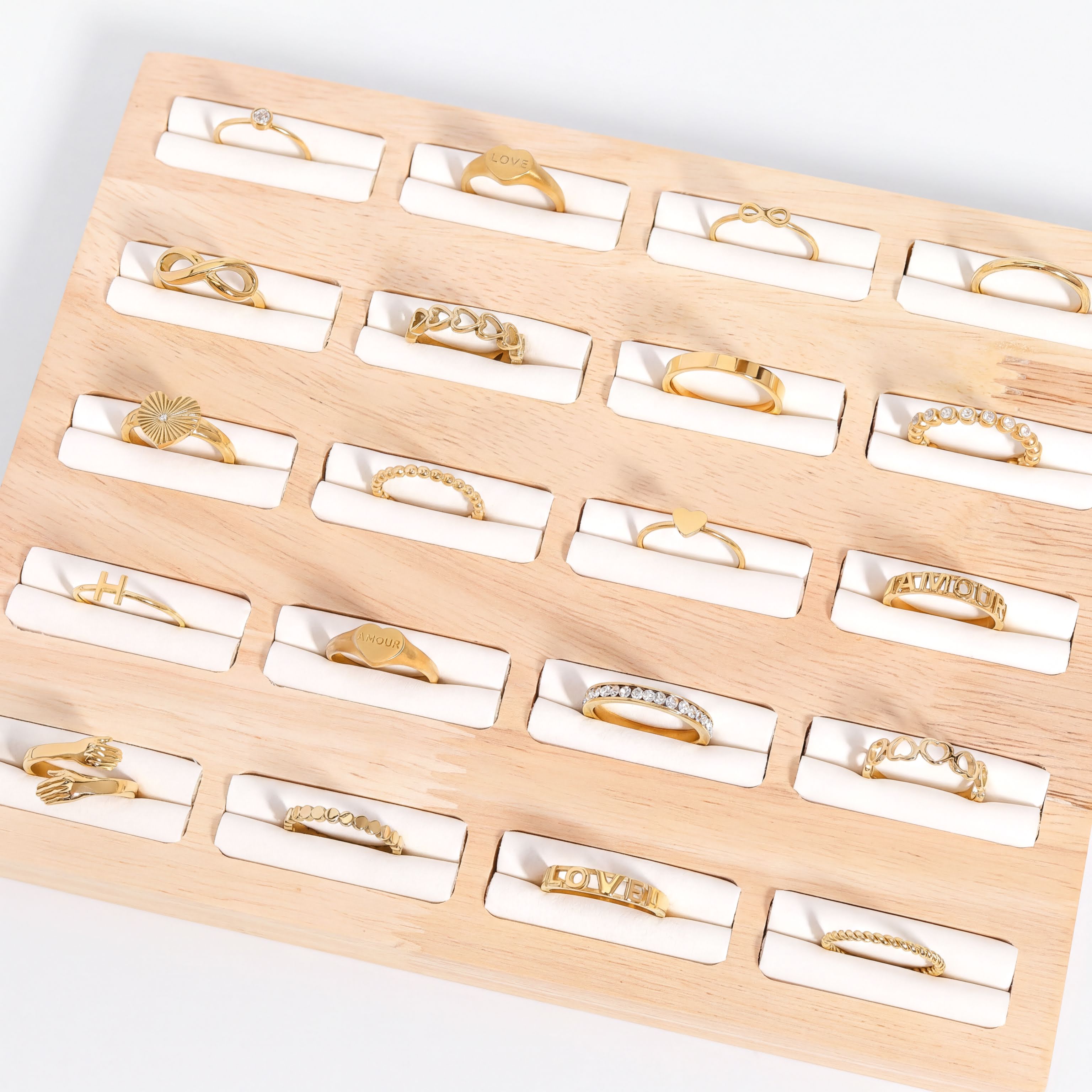 a collection of various gold rings arranged on a wooden display.