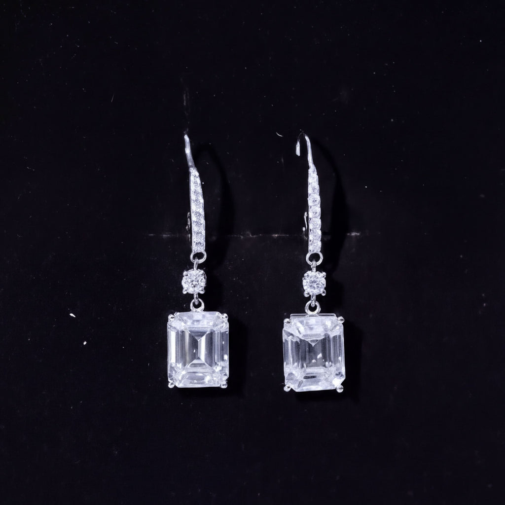 A pair of elegant diamond earrings with large, clear gemstones set in a silver frame.