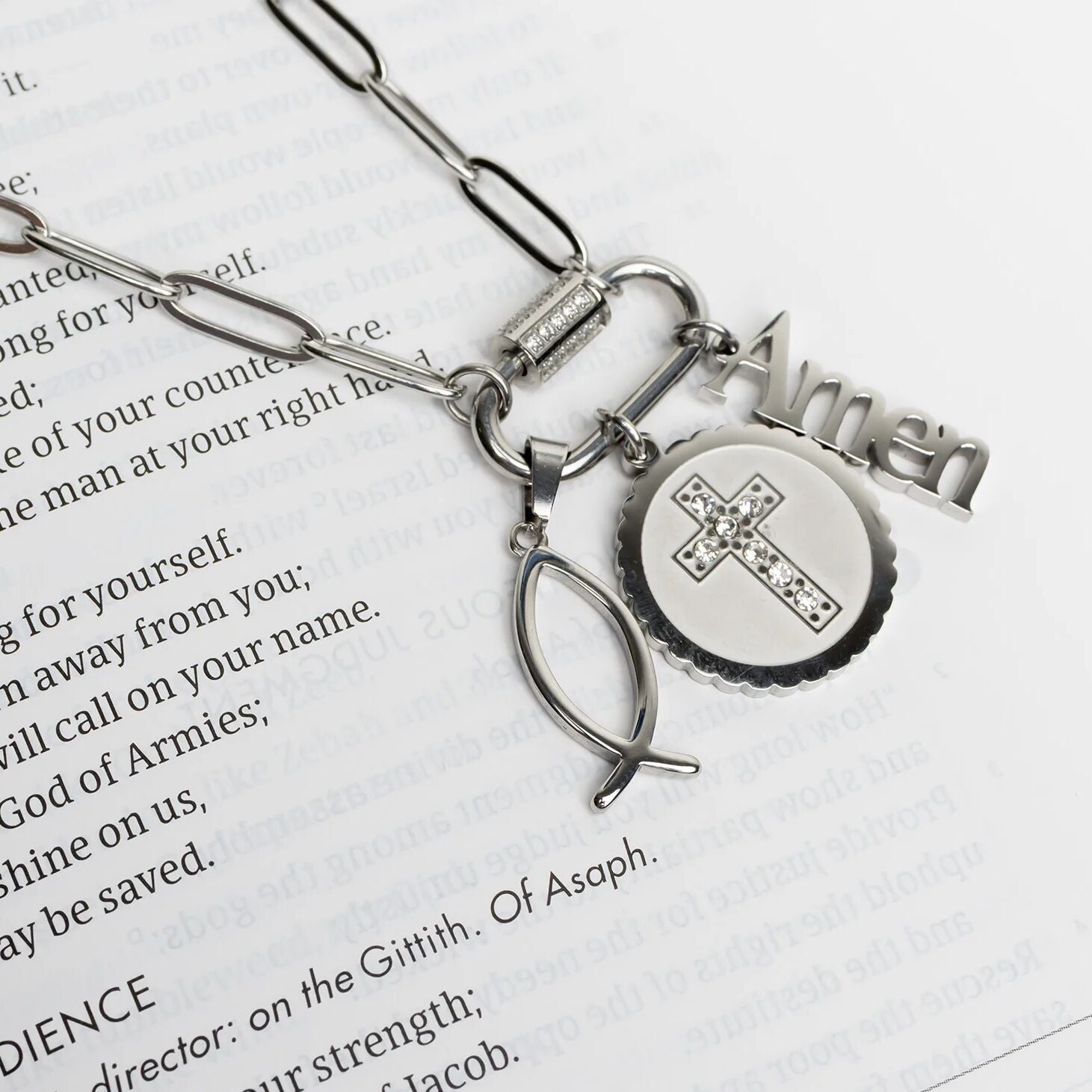 Silver necklace with religious charms on a book page