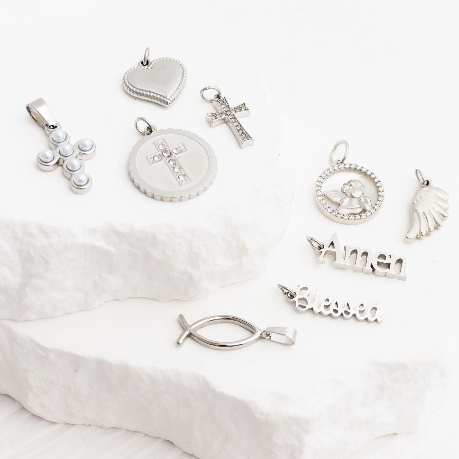 Collection of silver pendants on a white fabric background