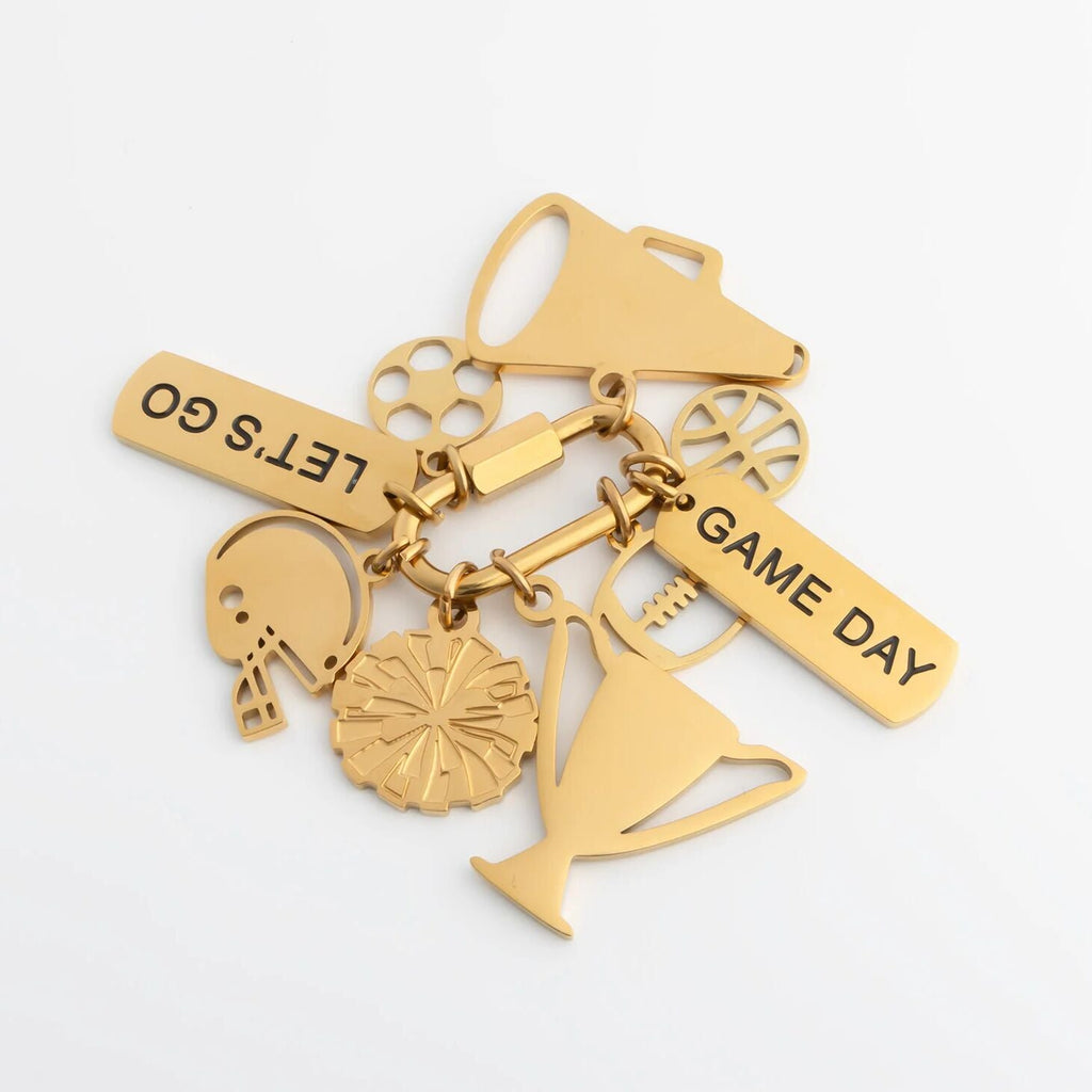 Gold charm bracelet with various charms on a white background