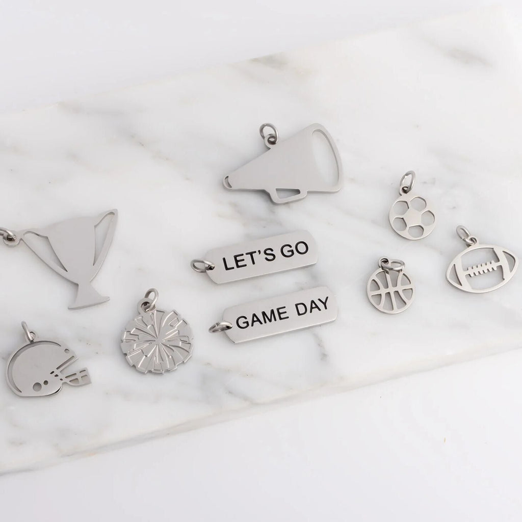 Collection of silver charms on a marble surface