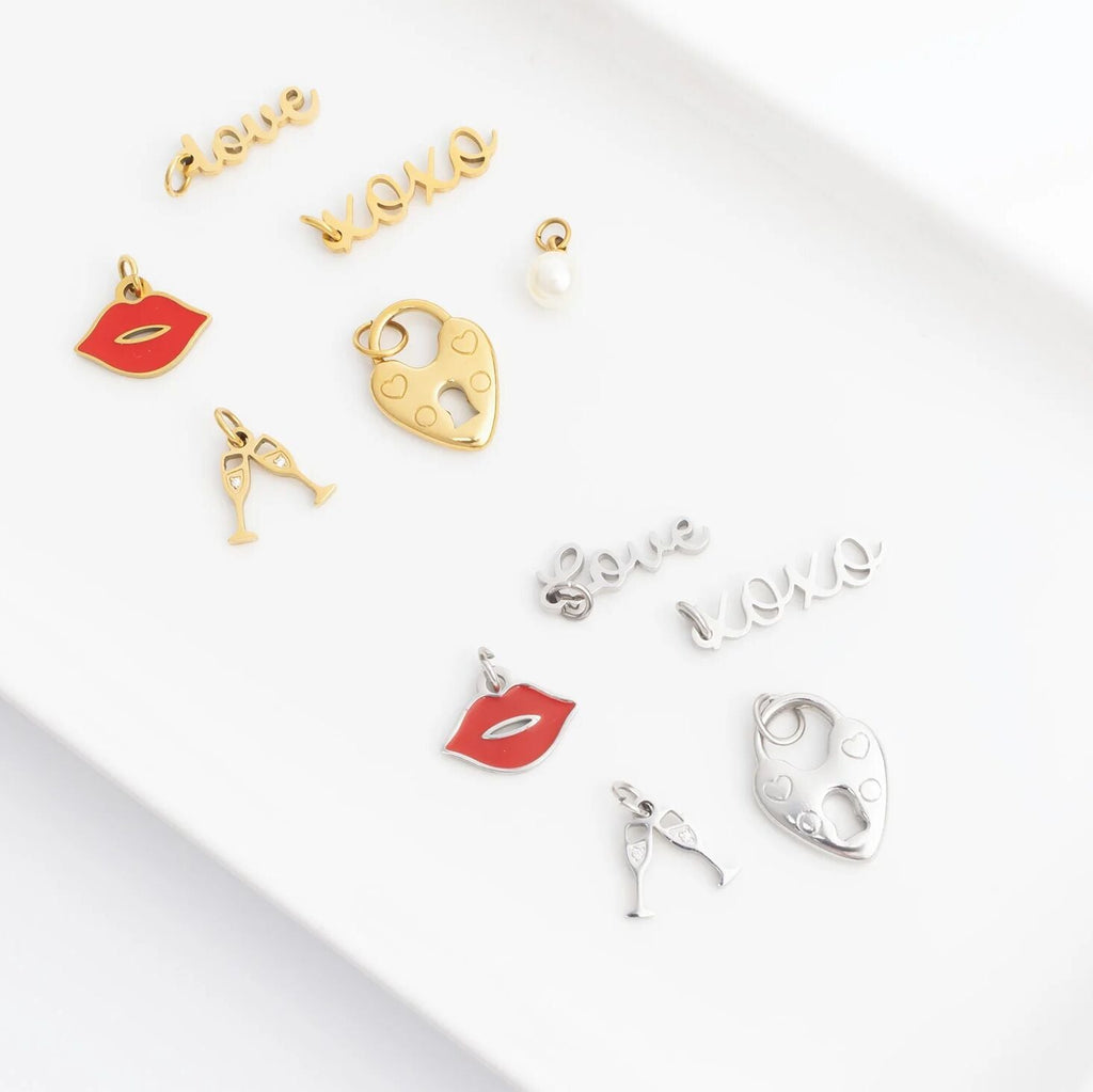 Collection of gold and silver charms on a white surface