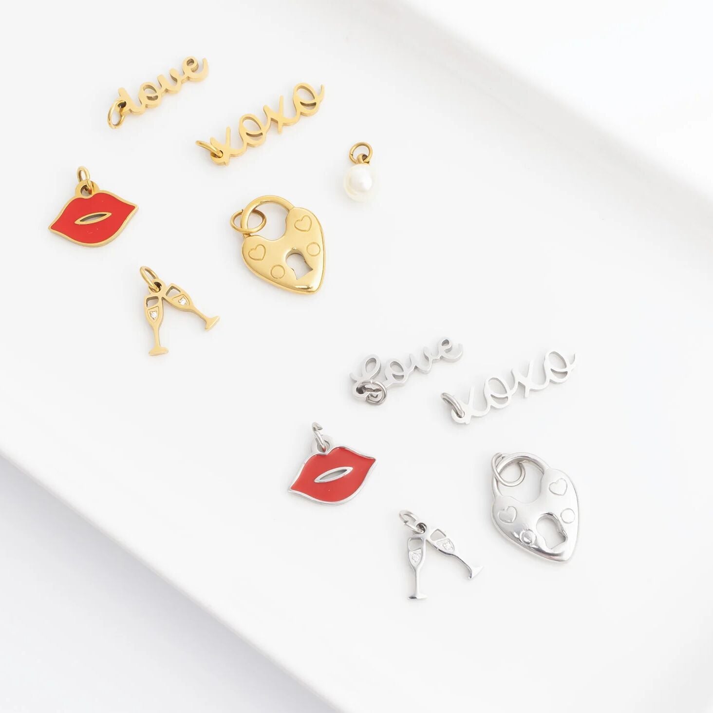 Collection of gold and silver charms on a white surface