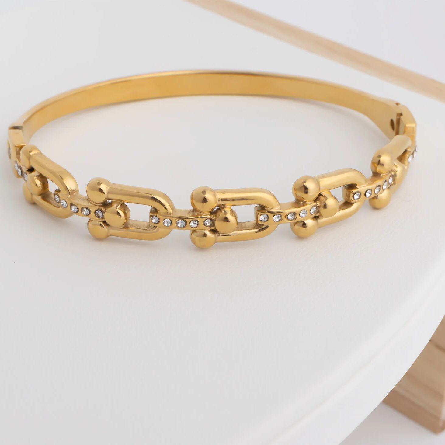 Gold chain bracelet on a white surface