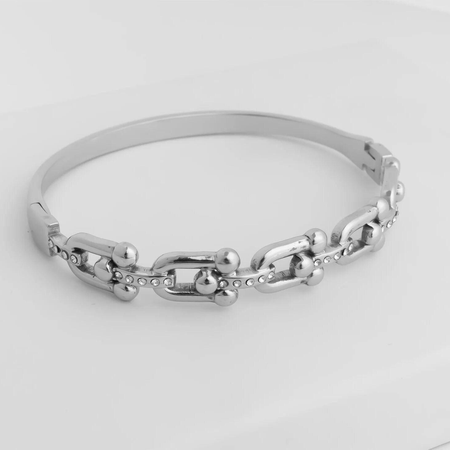 Silver chain bracelet on a light gray background