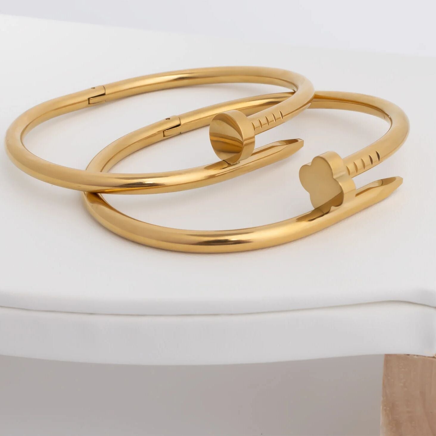 Gold bangles on a white surface