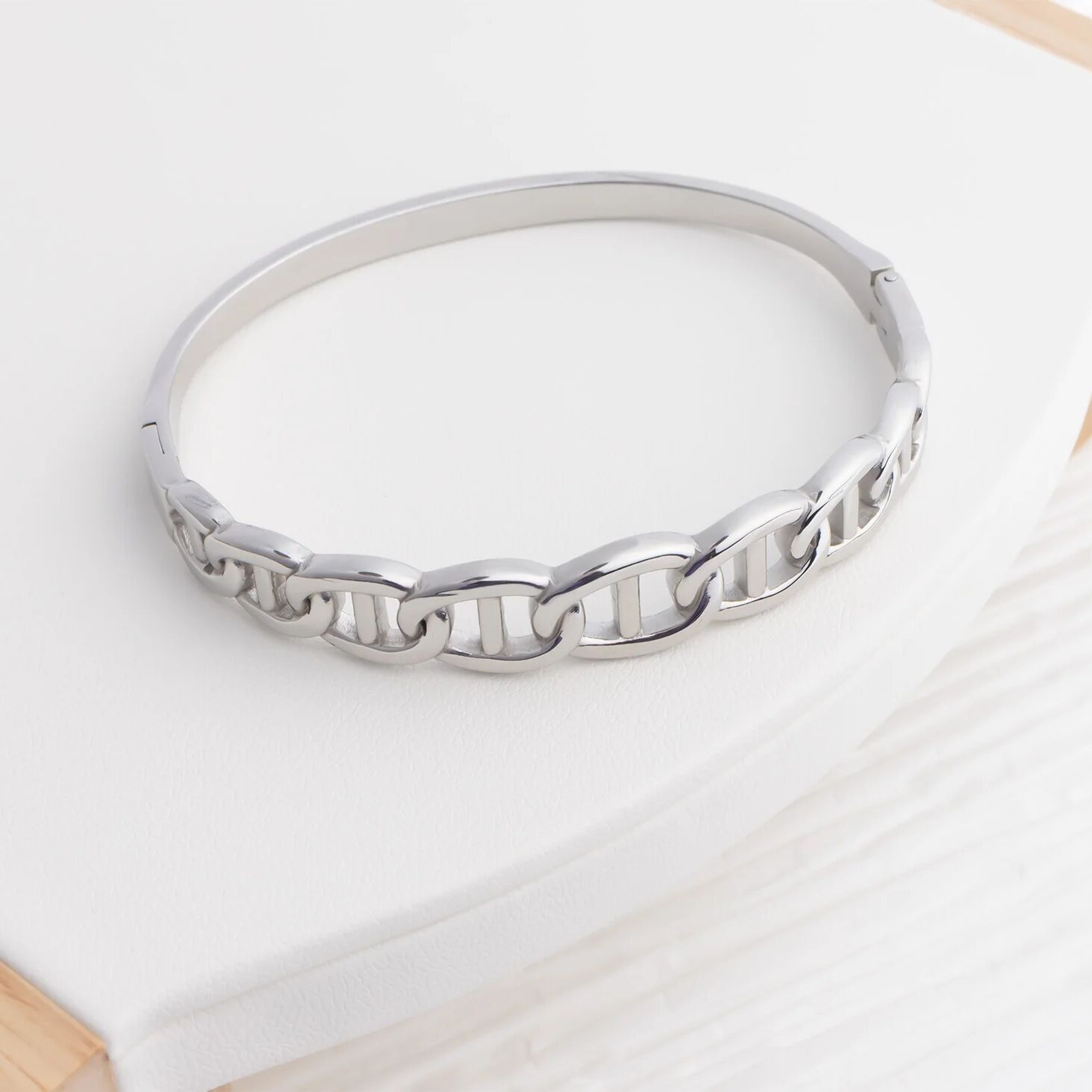 Silver bracelet on a light wooden surface