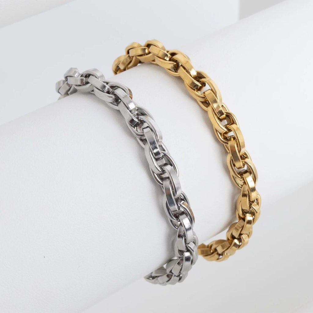 Two chain bracelets, one silver and one gold, on a white background
