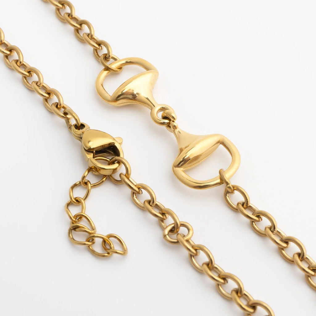 Close-up of a gold Horsebit Bracelet with lobster clasp on a white background