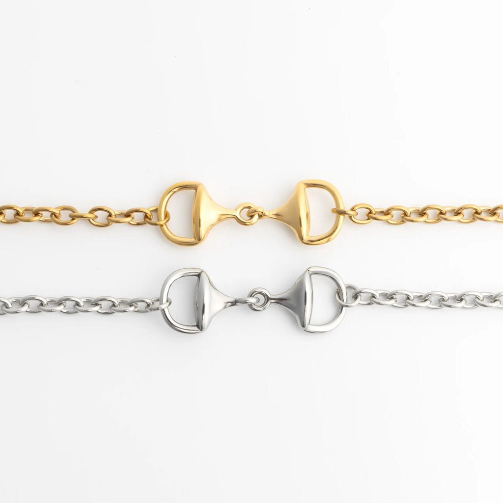 Two gold and silver horse bit bracelets on a white background