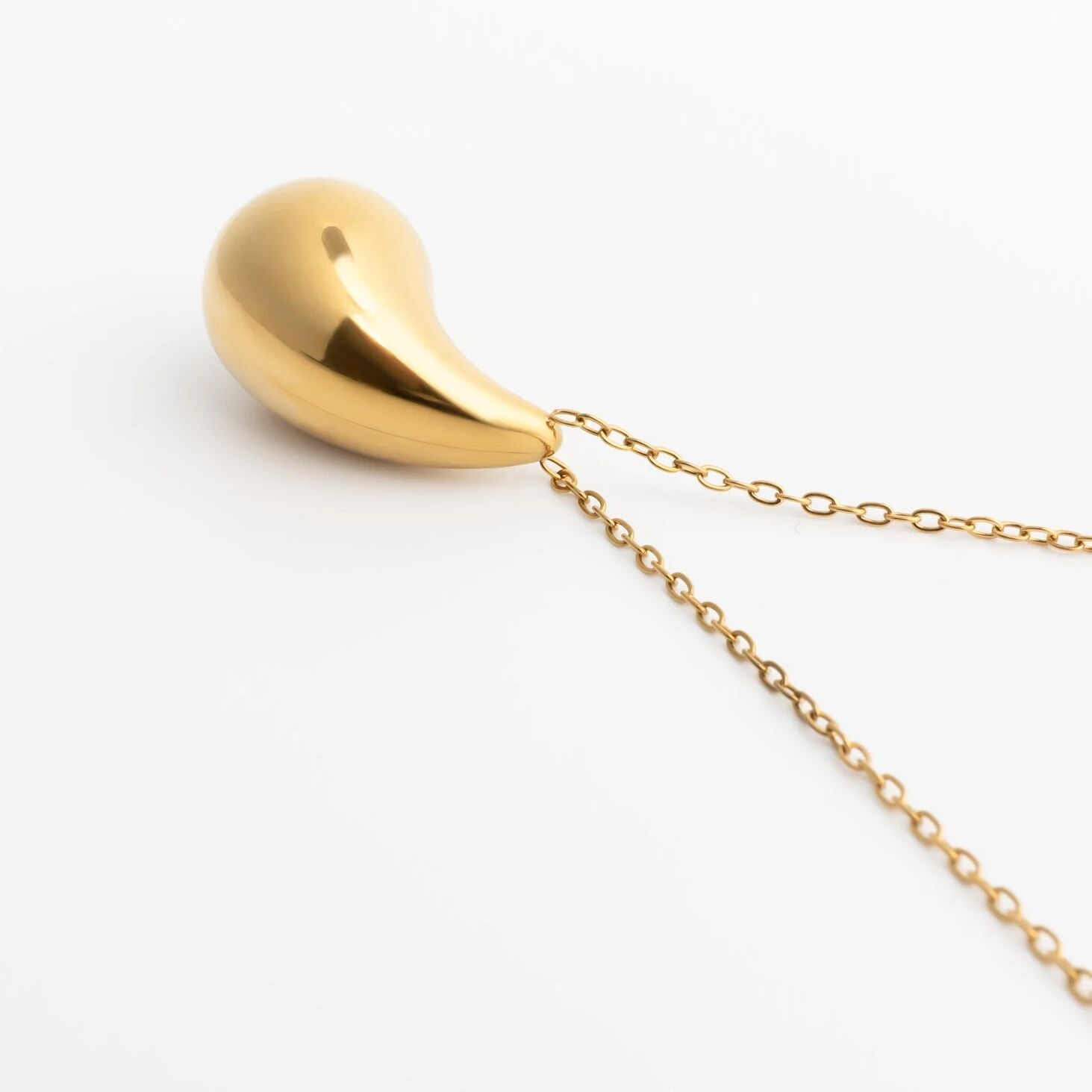 Gold Tear Drop Charm Necklace against a white background