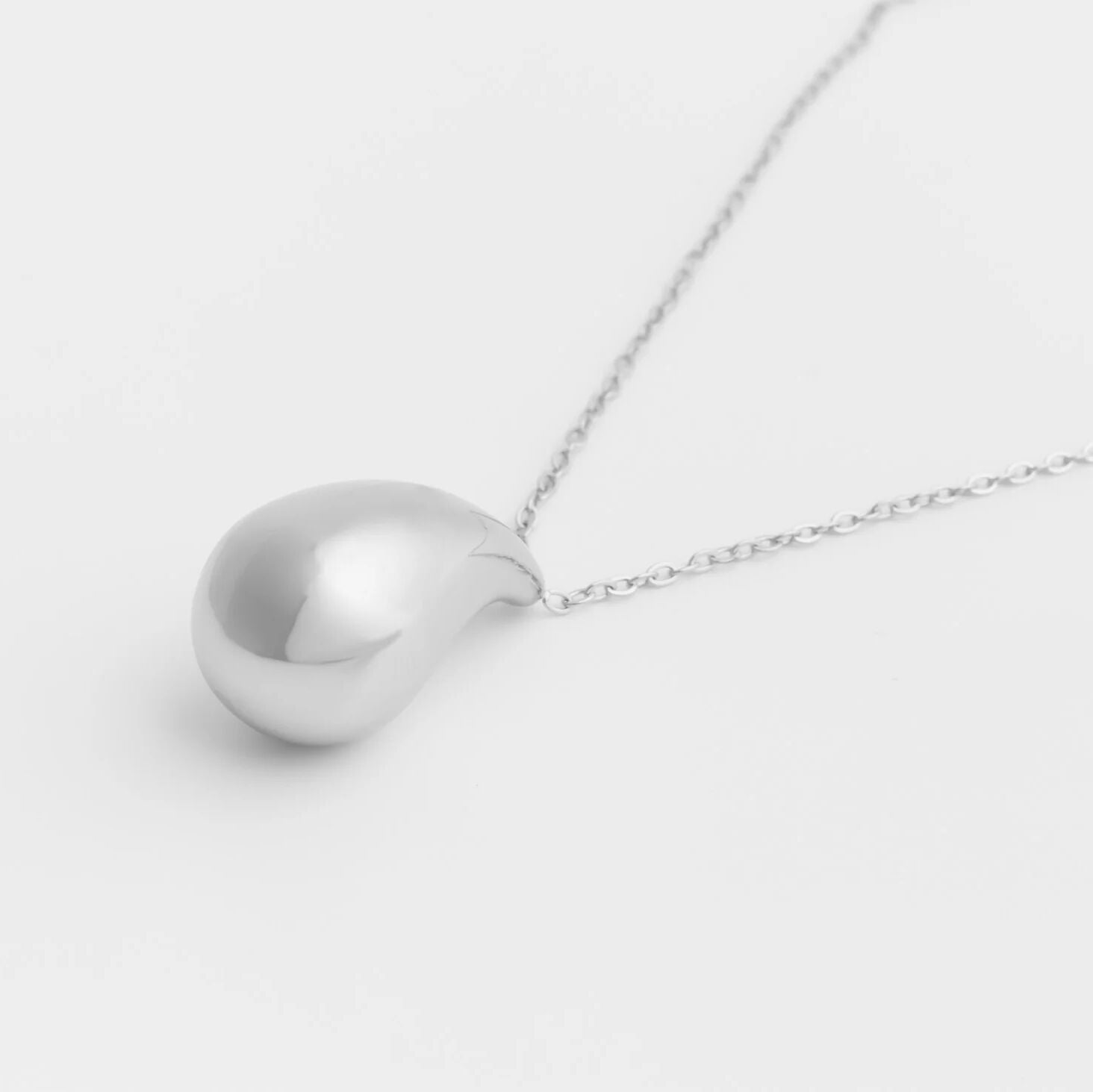 Silver Tear Drop Charm Necklace on a light gray background