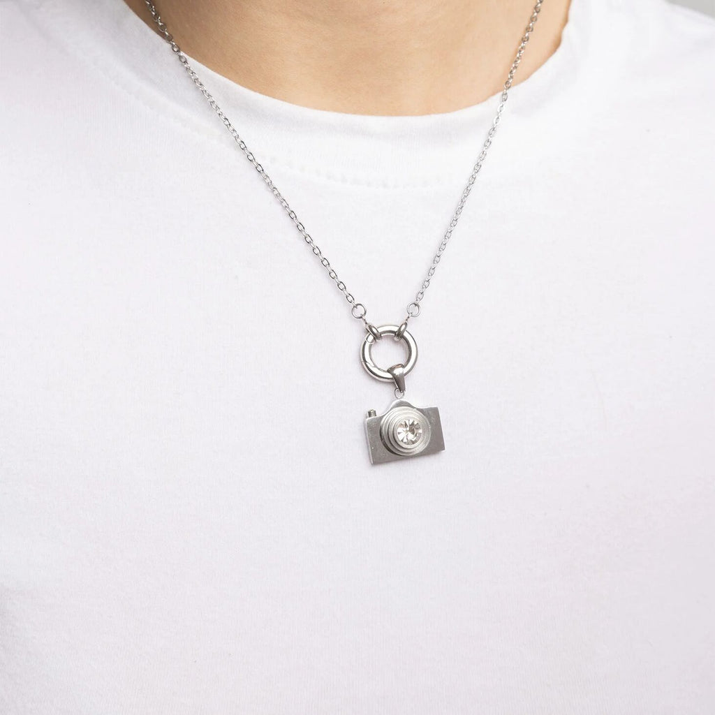 Silver camera-shaped pendant necklace on a white background