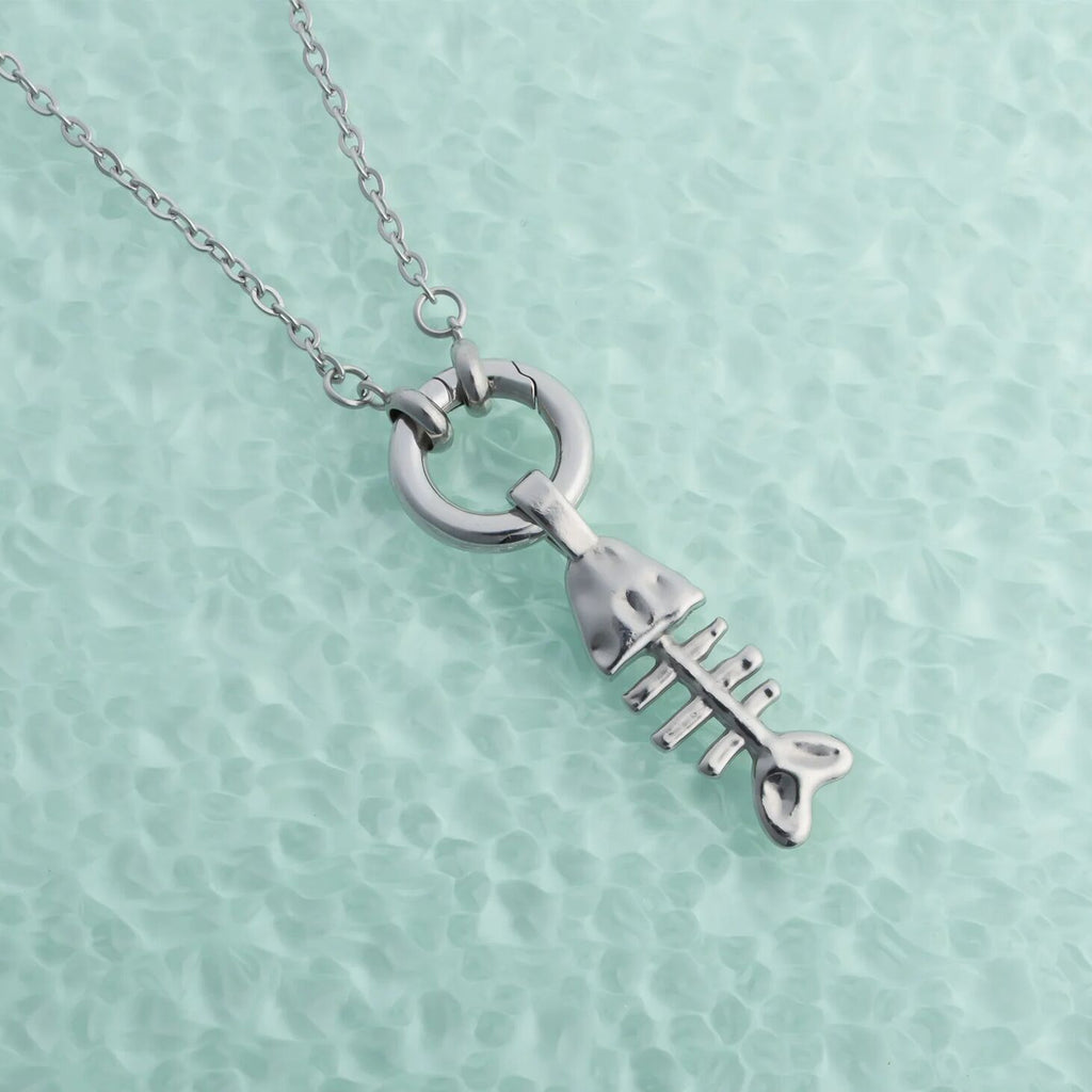Silver necklace with a unique pendant on a light green textured background