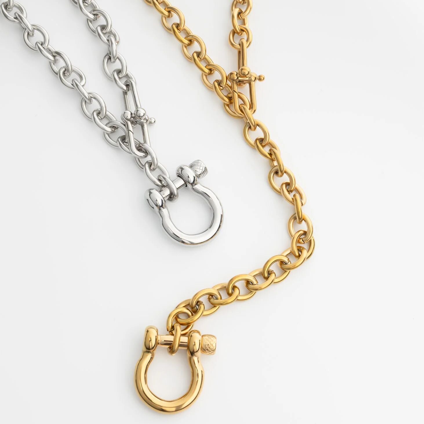 Two chain Y Necklace with Horse shoe Carabiners, one silver and one gold, on a white background.