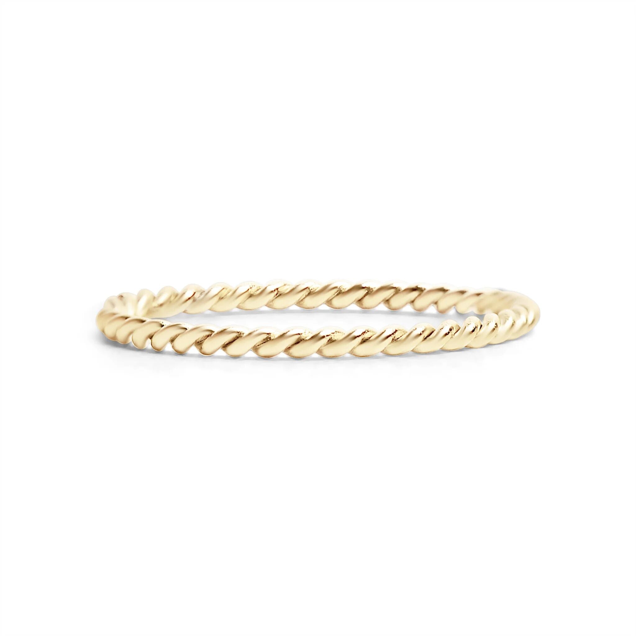 Gold ring with a rope design on a white background