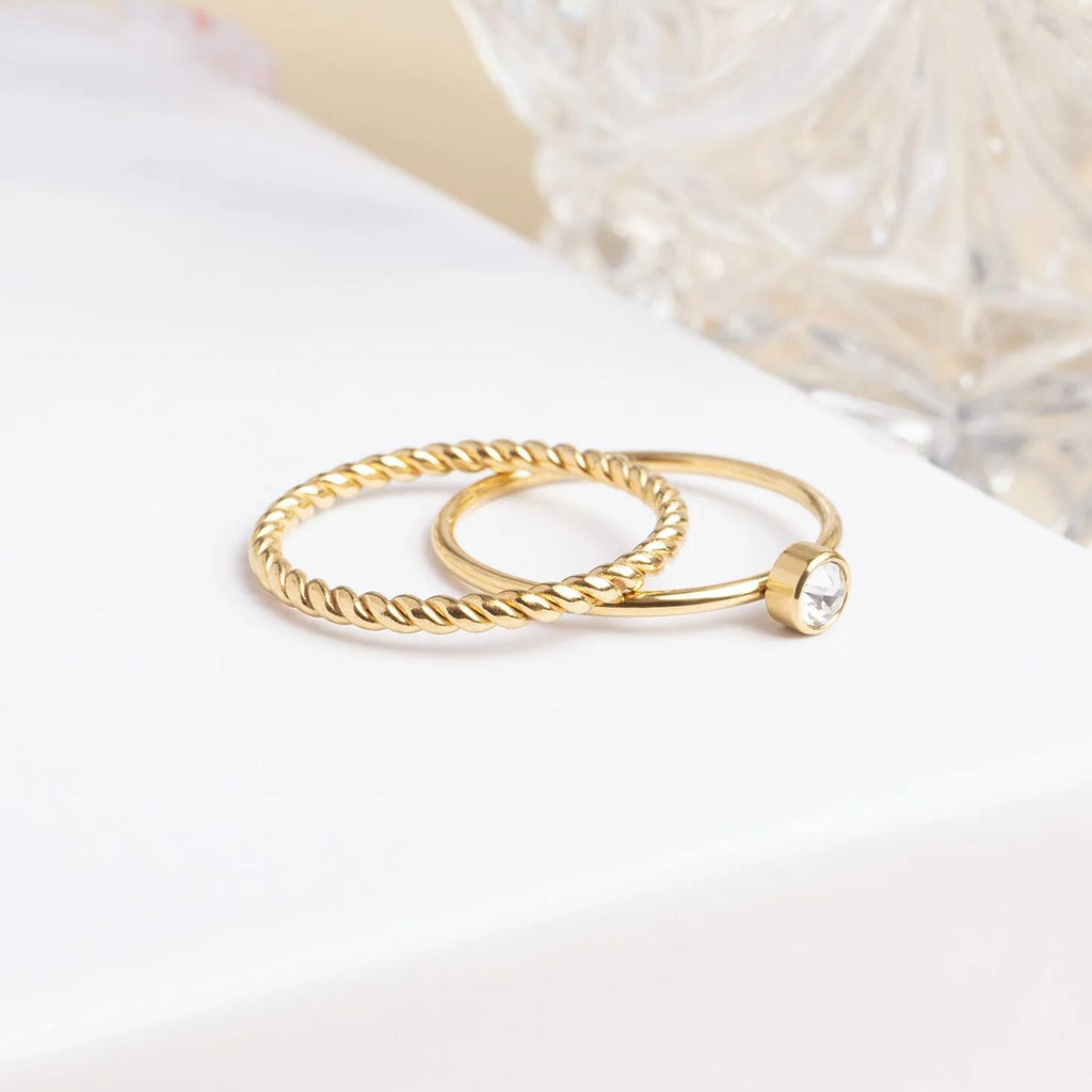 Gold ring with a small gemstone on a white surface