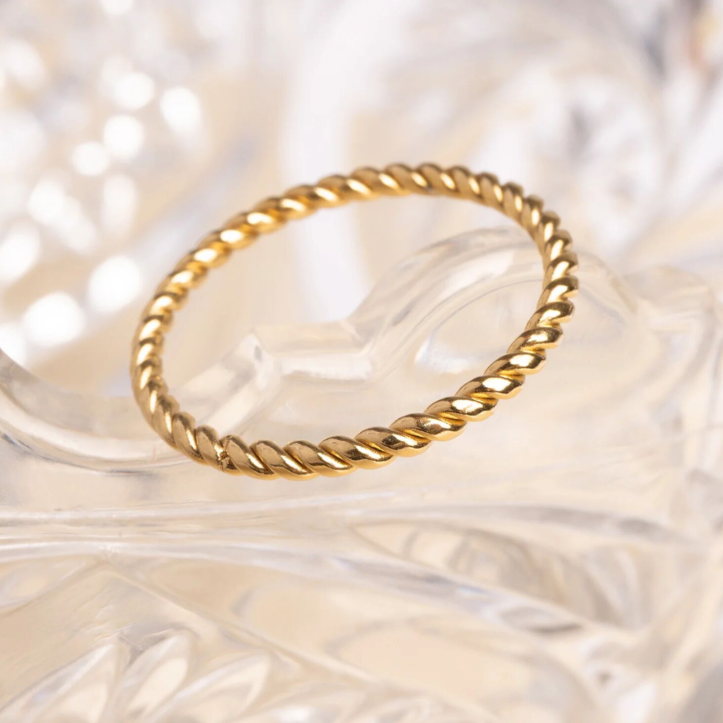 Gold ring with a textured design on a soft, blurred background
