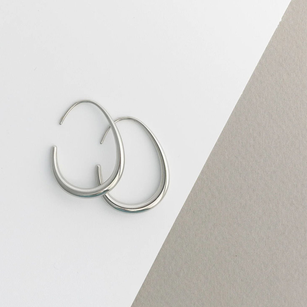 Silver hoop earrings on a light gray background