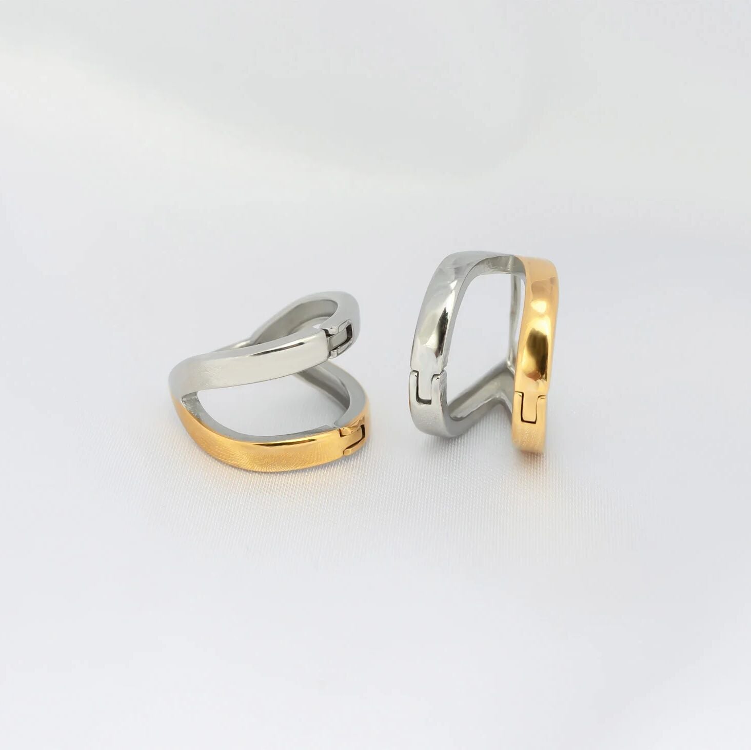 Two gold and silver rings on a light gray background