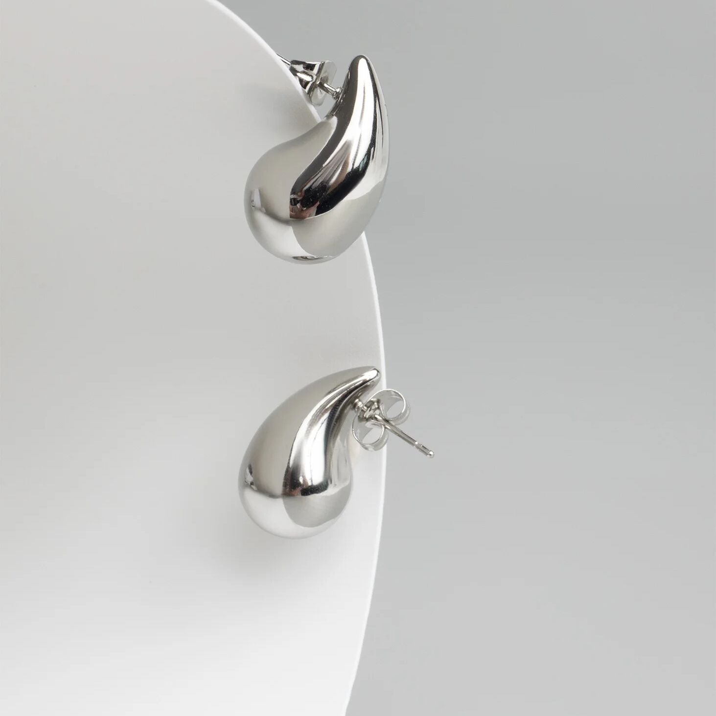 Pair of silver earrings on a light gray background