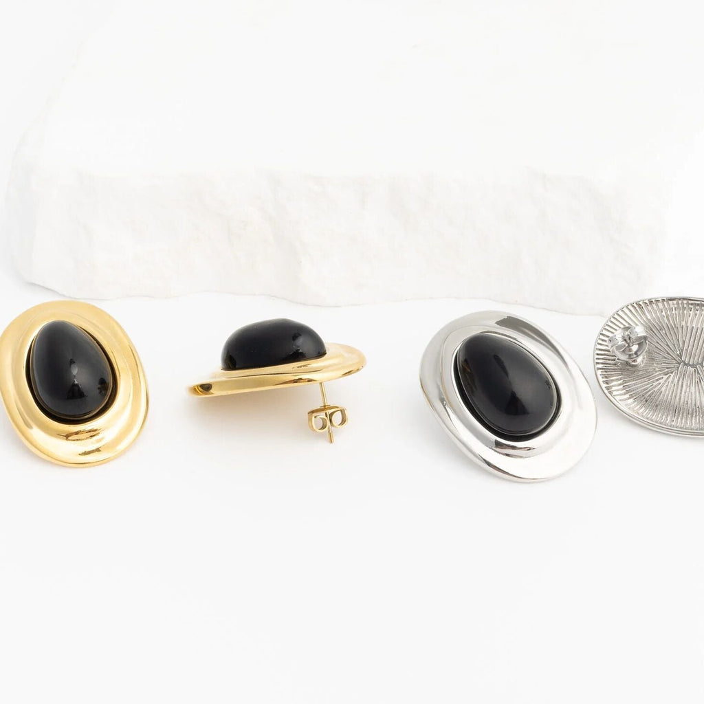 Pair of gold and silver Black Enamel Stud Earrings on a white background