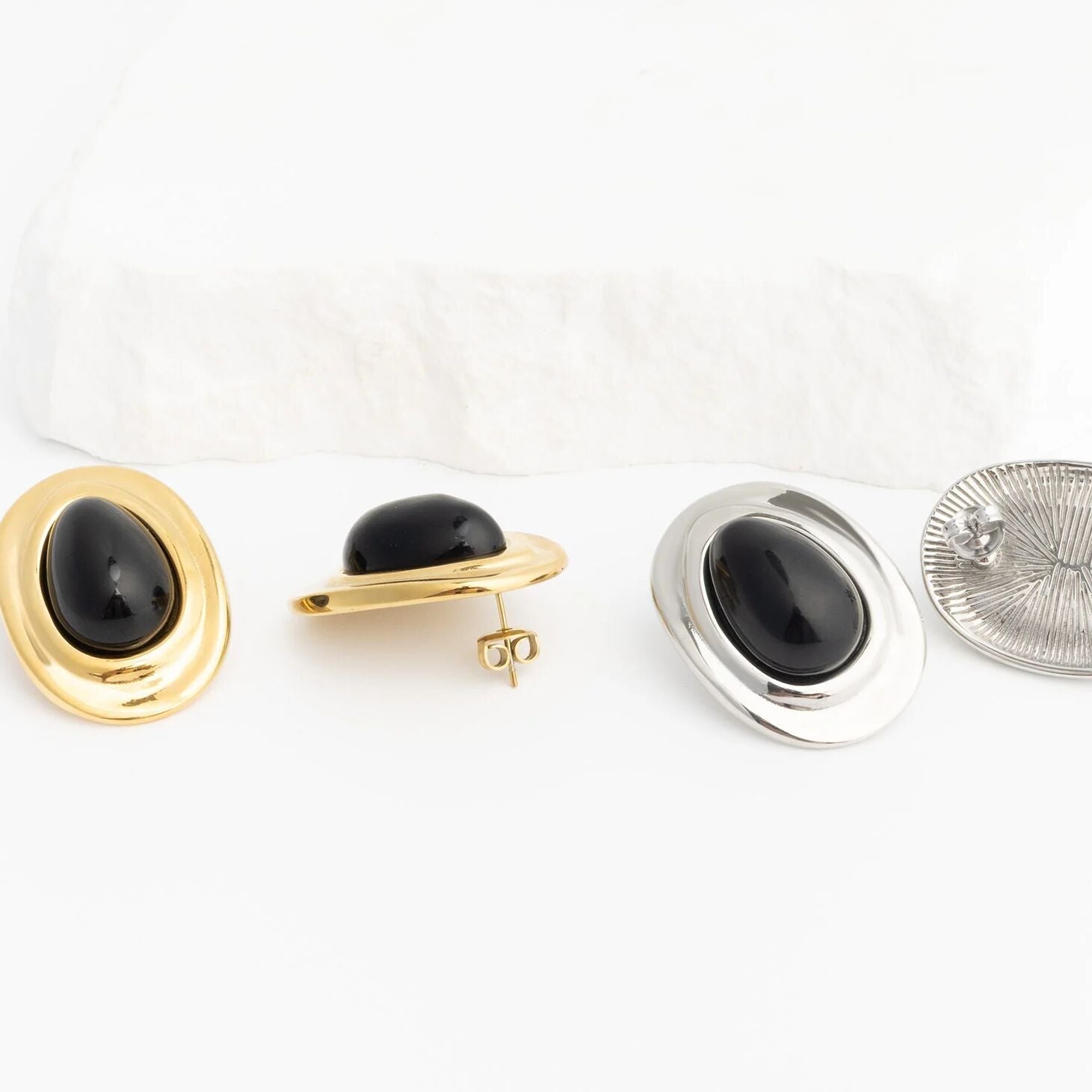 Pair of gold and silver Black Enamel Stud Earrings on a white background