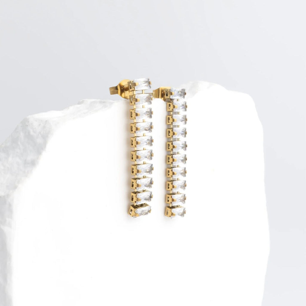 Gold and silver hoop earrings on a white surface