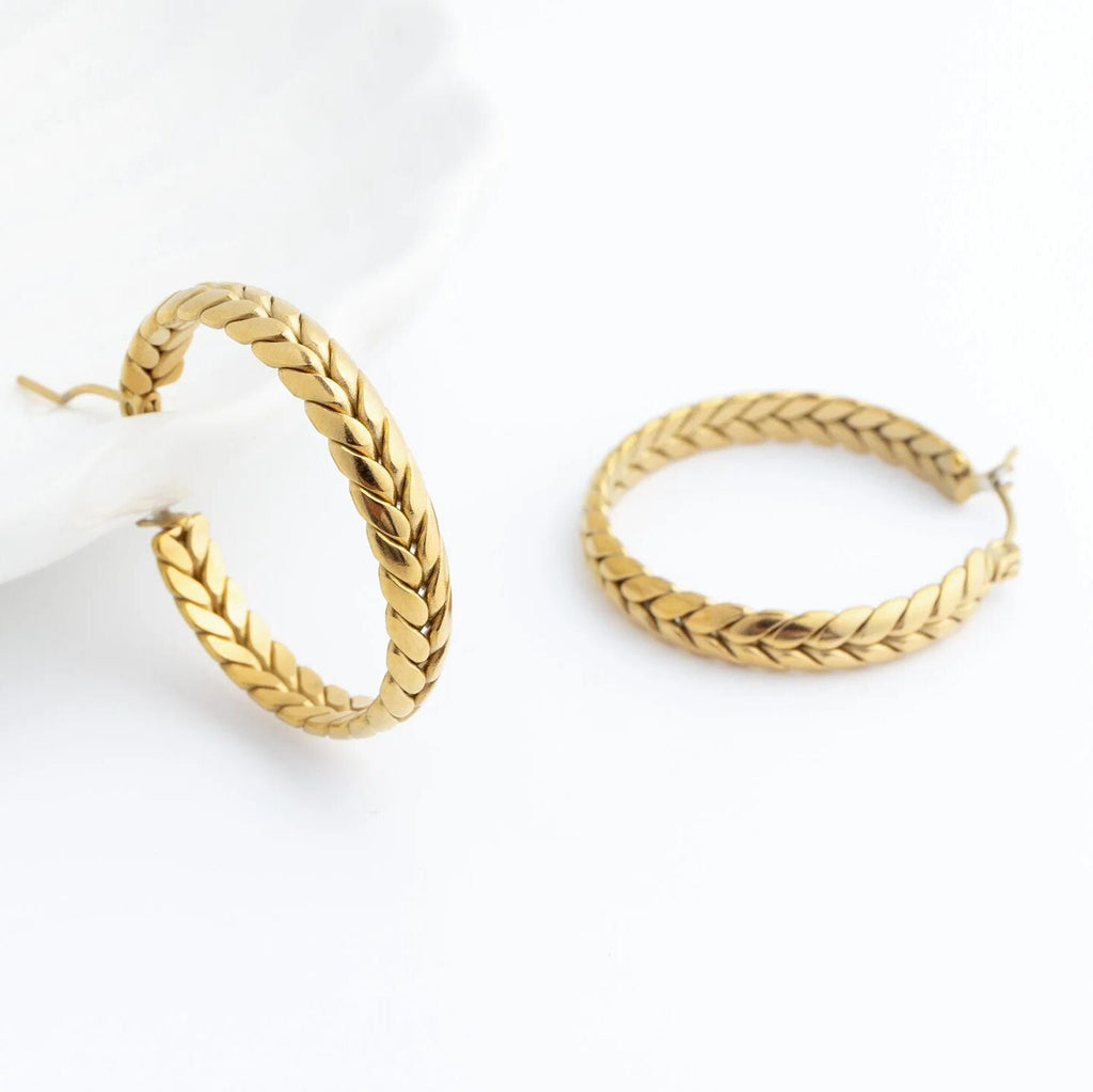 Pair of gold Braided Hoop Earrings on a white background