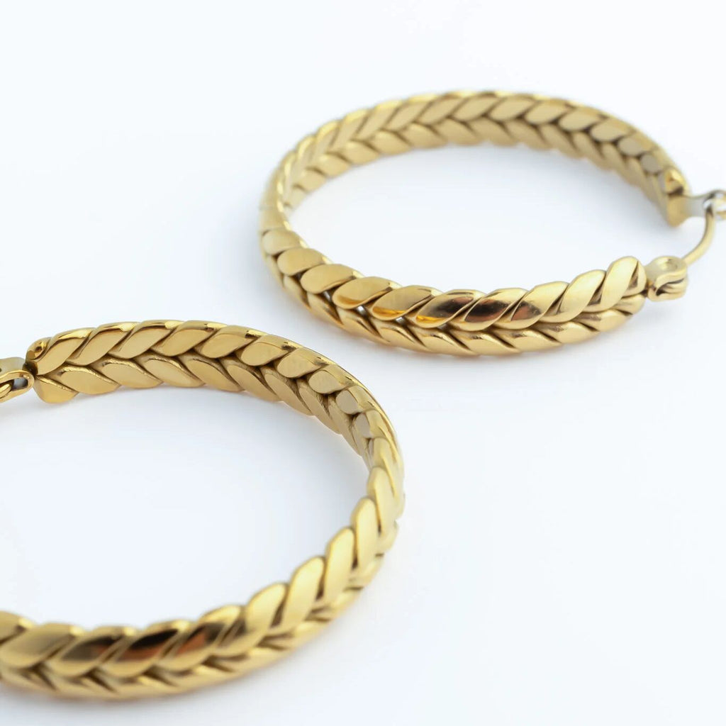 Pair of gold Braided Hoop Earrings on a white background