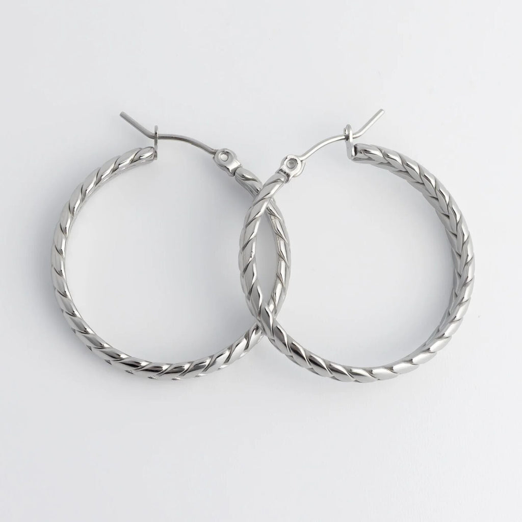 Pair of silver Braided Hoop Earrings on a white background