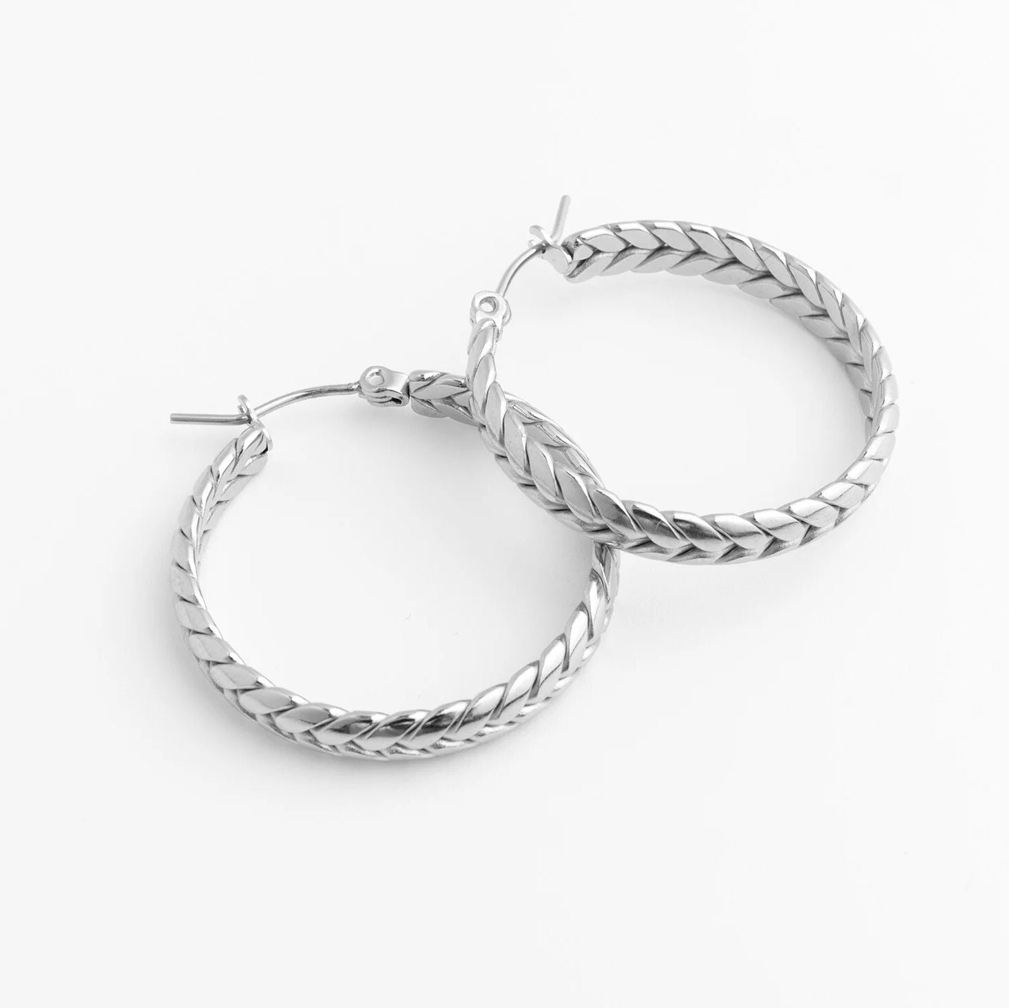 Pair of silver Braided Hoop Earrings on a white background