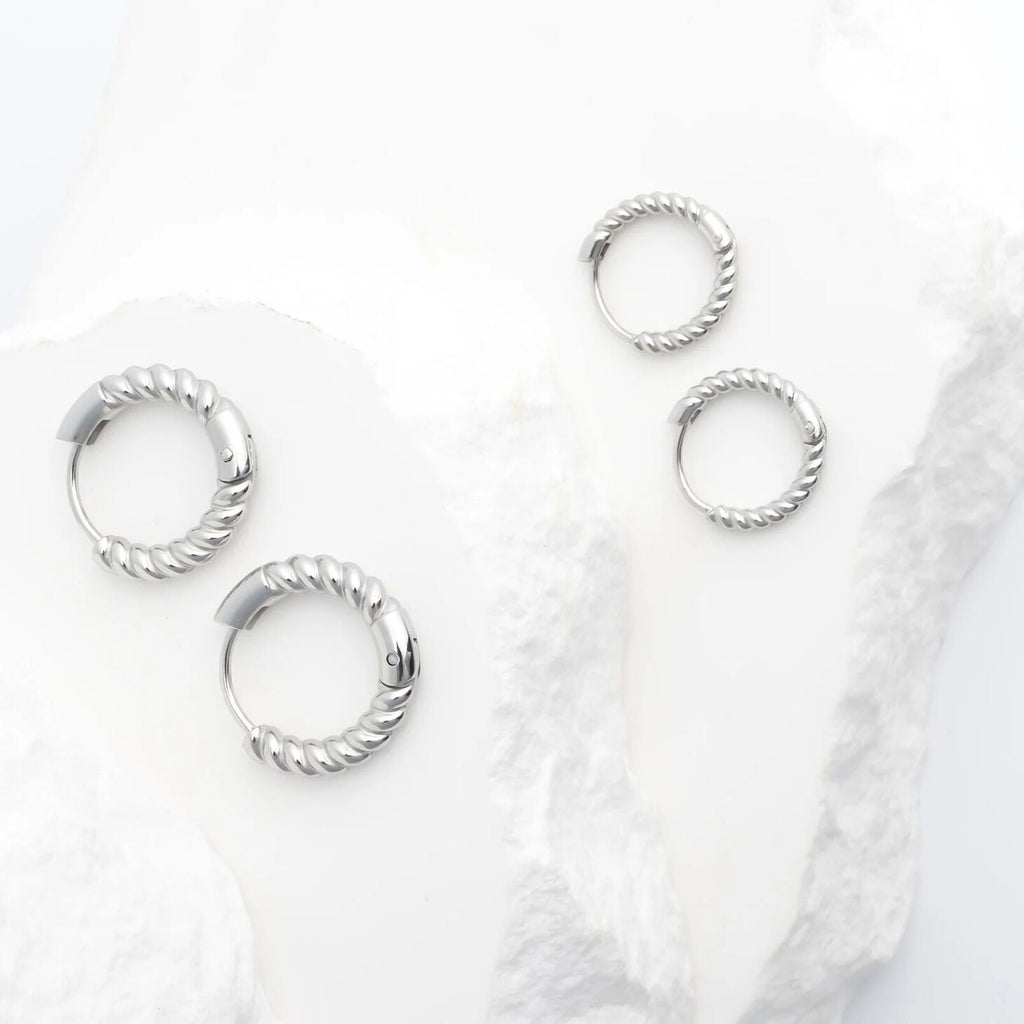 Set of silver hoop earrings on a white background