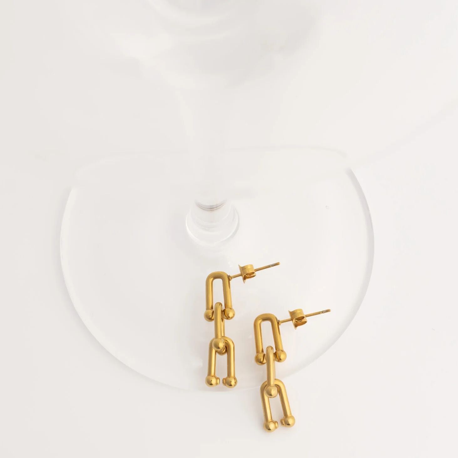 Gold chain-style earrings on a white background