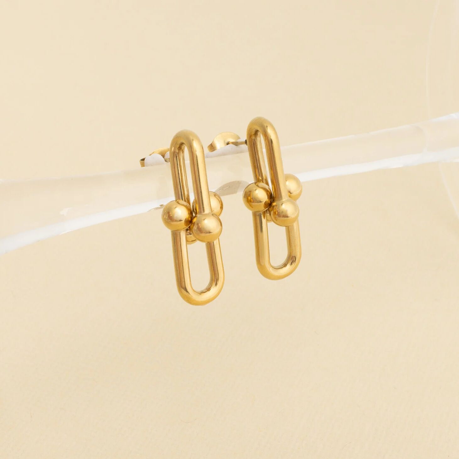 Gold hoop earrings on a beige background