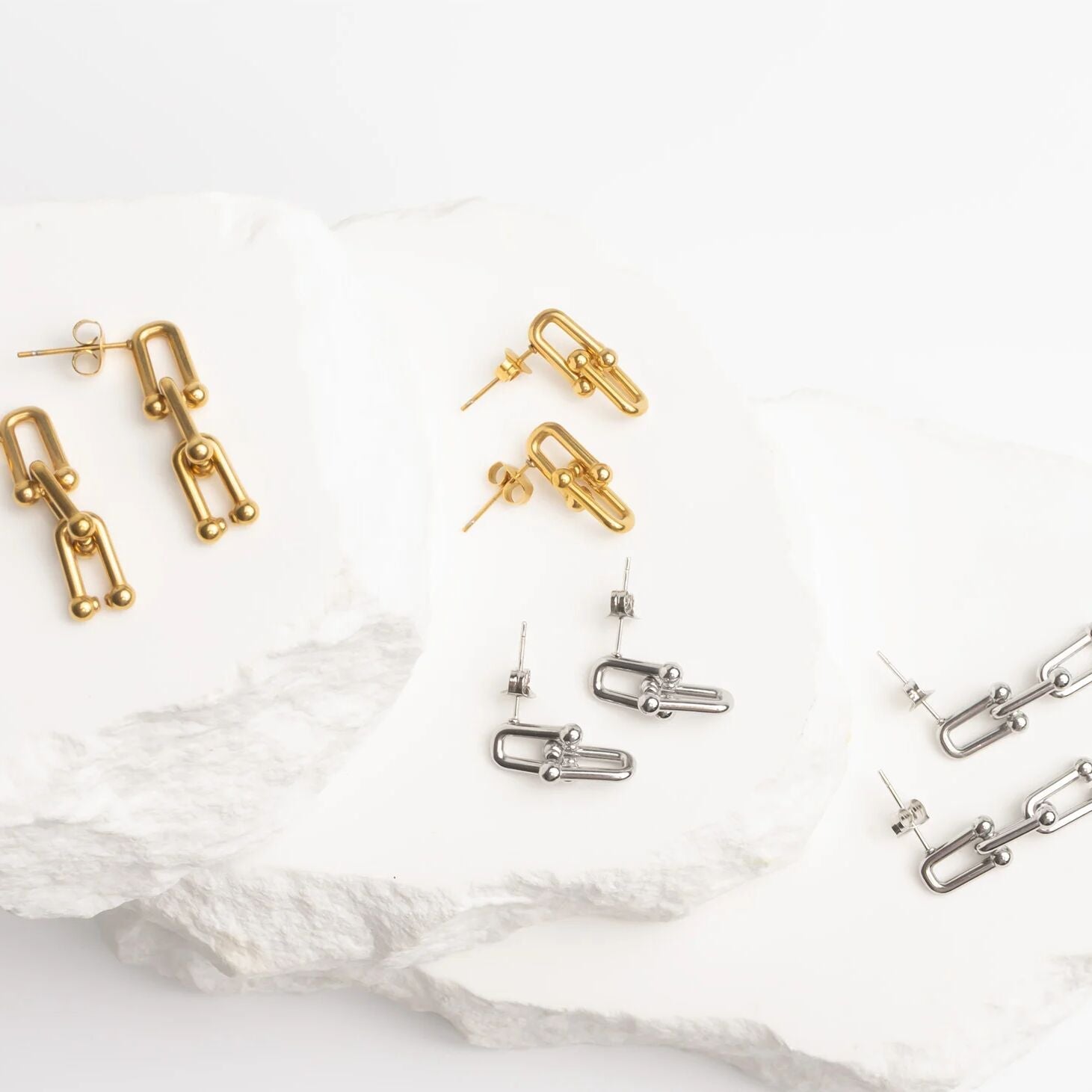 Gold and silver earrings on a white background