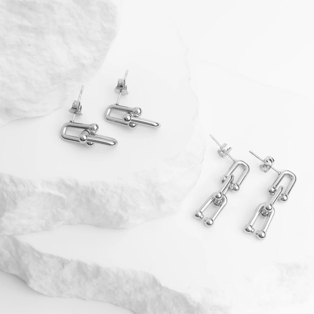 Silver earrings on a white fabric background