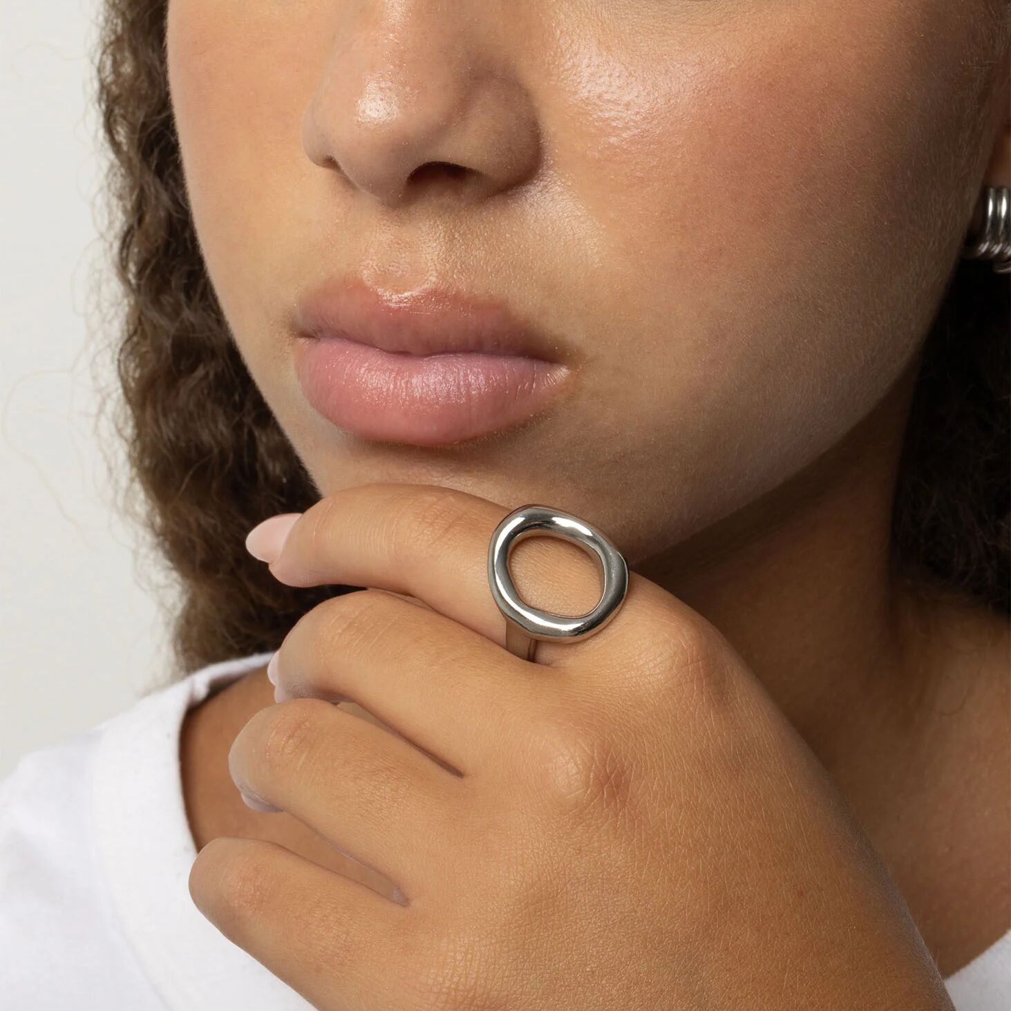Close-up of a person wearing a silver Oval Motif Ring  on their finger.