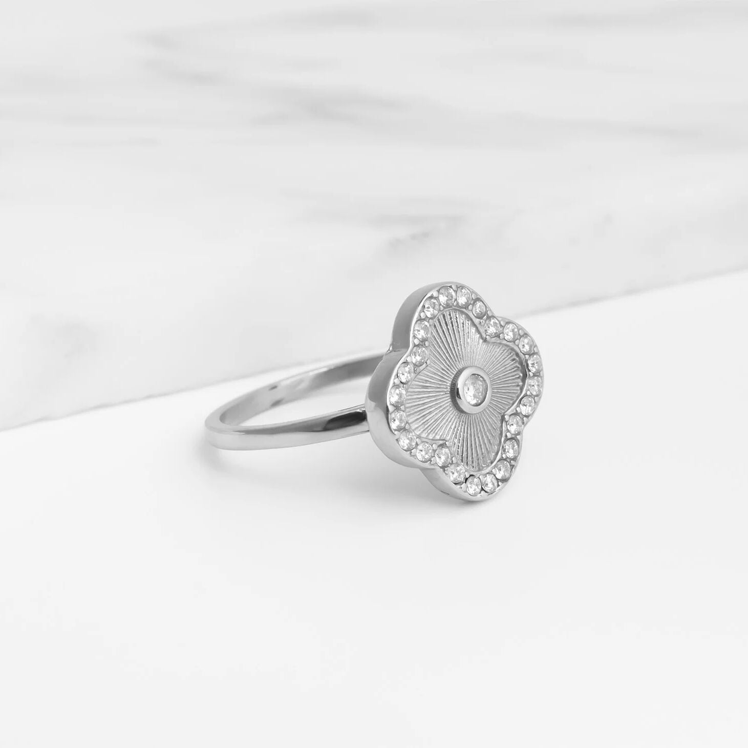 Silver Floral Motif Ring with floral design on a white marble surface