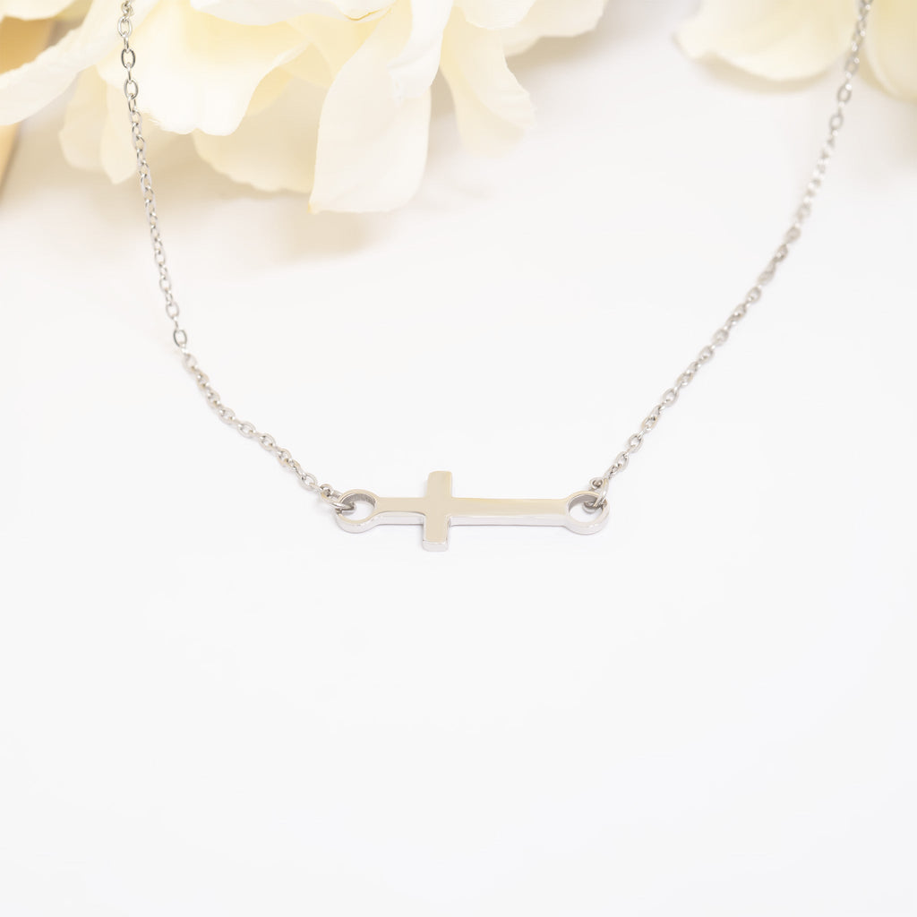 Silver cross necklace on a white background